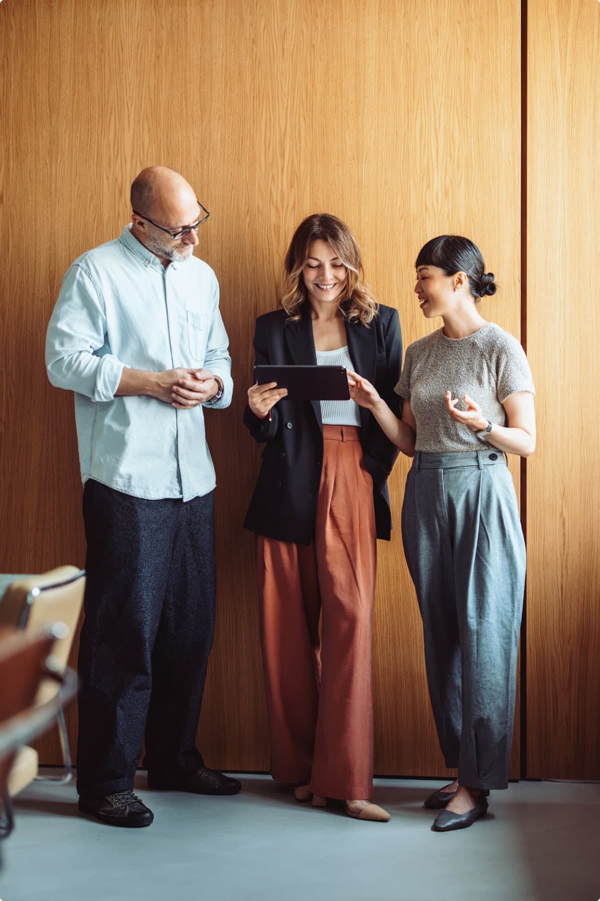 Colleagues Discussing Work on Tablet in Modern Office