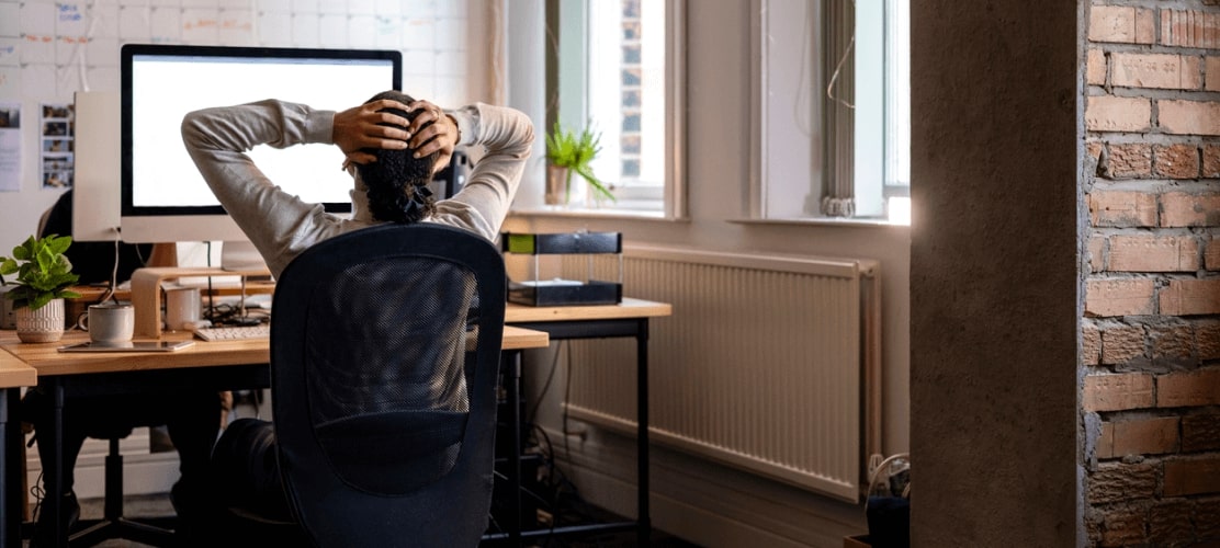 man leaning back with hands on head