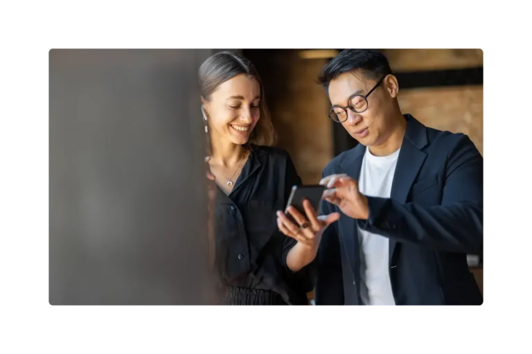 Men and woman talking looking at a phone screen