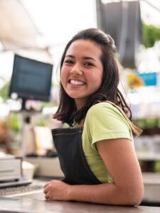 young retail employee sitting at the cash register