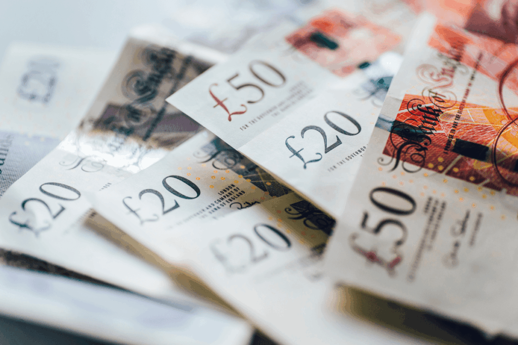 Various 50 and 20 pounds notes scattered on a table