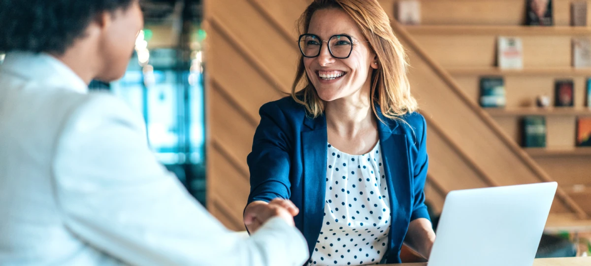 woman and man shaking hands at work