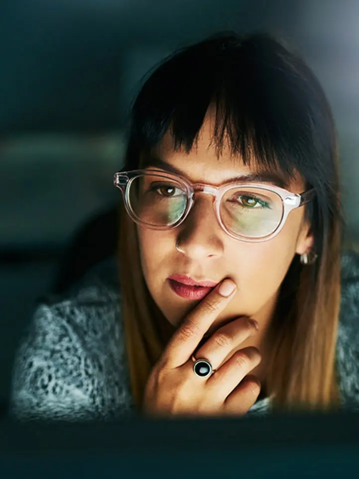 Woman in the office looking at a computer screen, very focused