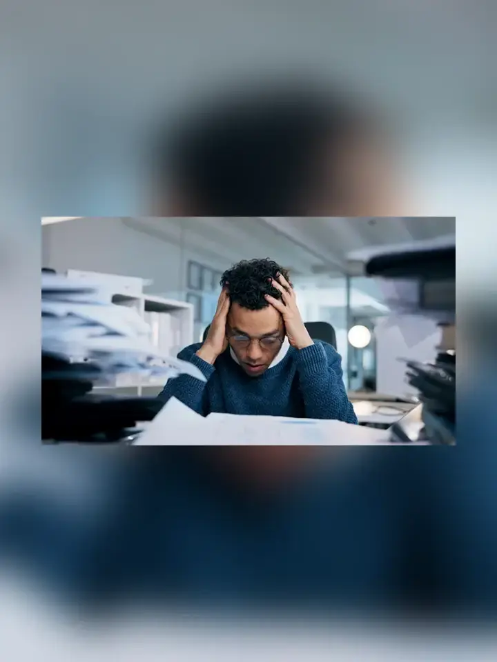 Image of stressed out man at his work desk