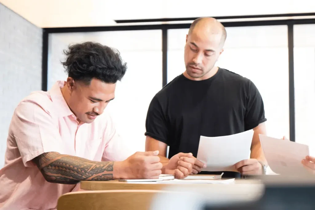 2 men talking and analysing some documents