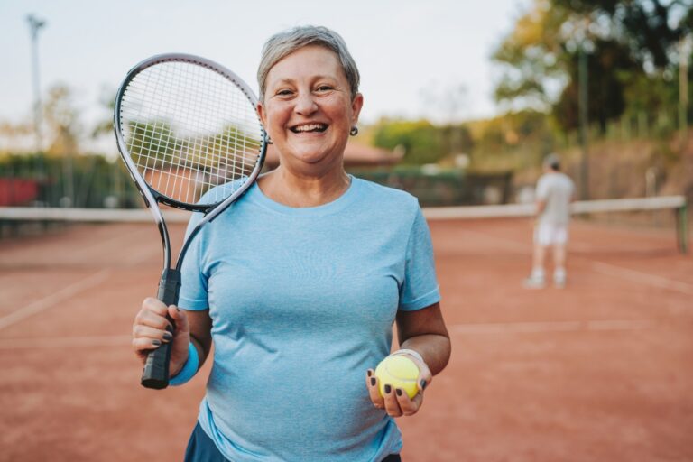 women playing tennis, holding a tennis racket