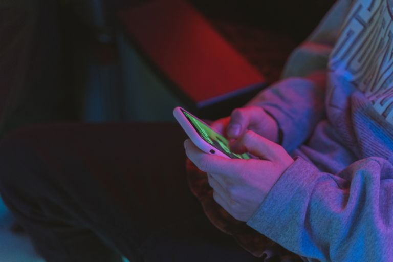 person in the dark, hiding on their phone