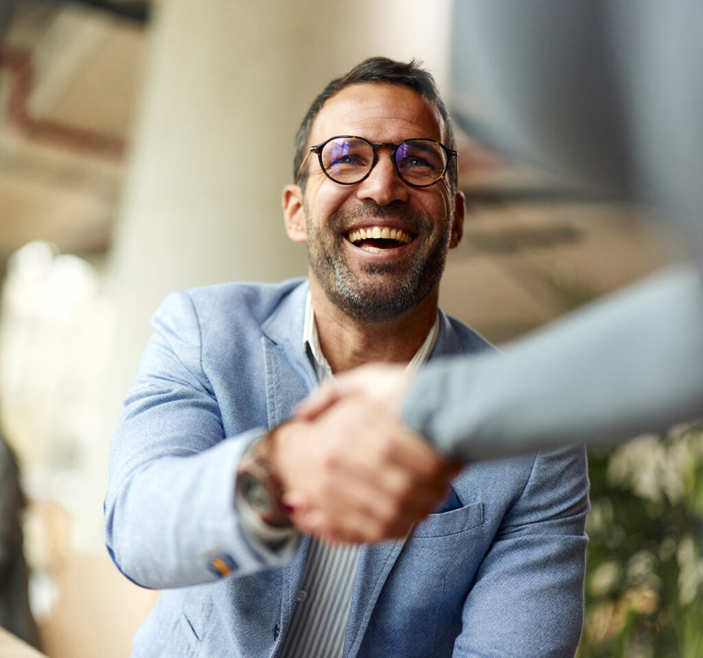 2 people shaking their hands and smiling